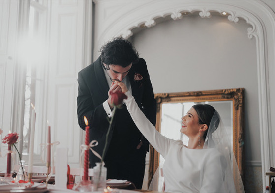 Groom kisses brides hand at top table